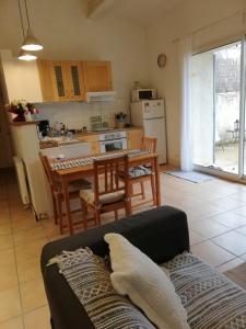 a living room with a couch and a kitchen with a table at La Forge in Gignac