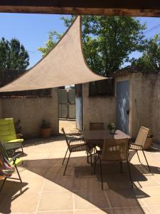 a patio with a table and chairs under a tent at La Forge in Gignac