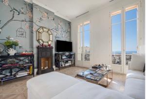 a living room with a white couch and a fireplace at Luxury Penthouse Villa Belle Epoque Monaco GP in Cap d'Ail