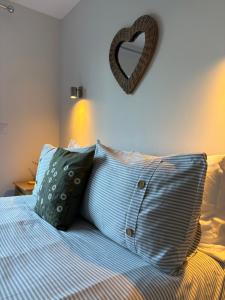a bed with two pillows and a heart on the wall at The Nest - Worcester in Worcester
