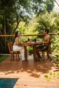 a man and a woman sitting at a table at Reserva Mazu in São Miguel dos Milagres