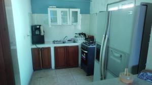 a kitchen with a stove and a refrigerator at Casa Del Mar Pedasí in Pedasí Town