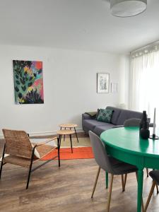 a living room with a couch and a table at Au perron avec garage et balcon à Ribeauville in Ribeauvillé