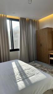 a bedroom with a large bed and a window at شقق سدايم in Jeddah