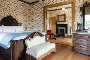 a bedroom with a bed with a dresser and a fireplace at Cosmopolitan Hotel in San Diego