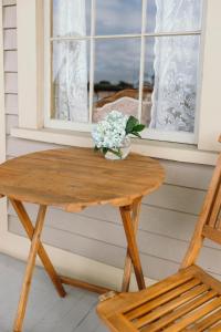 a wooden table with a vase of flowers and a window at Cosmopolitan Hotel in San Diego