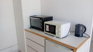 a microwave and a toaster oven on a counter at Departamento centro Gral Roca in General Roca
