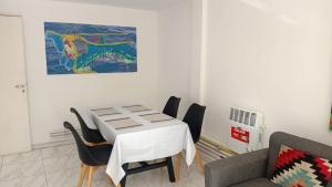 a dining room with a table and chairs and a painting at Departamento centro Gral Roca in General Roca