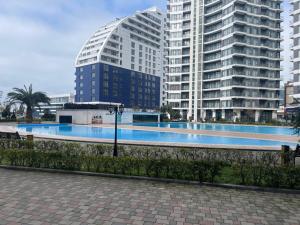 a large swimming pool in front of tall buildings at Ocean Grace Residence in Batumi