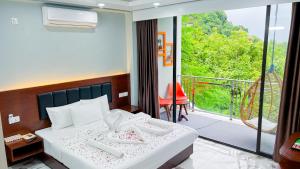 a hotel room with a bed and a balcony at Cloudy Inn Resort in Bāndarban