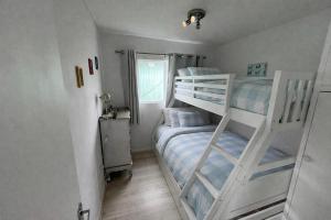 a bedroom with two bunk beds and a window at The Retreat Camber in Camber +22 photos