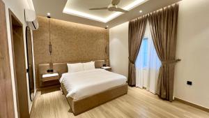 a bedroom with a white bed and a window at Aurhom By Royal Inn in Karachi