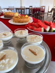 a table with plates of food and bowls of fruit at Pousada Sol Nascente in Mucuri