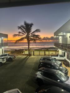 a group of cars parked in a parking lot near the beach at Pousada Sol Nascente in Mucuri