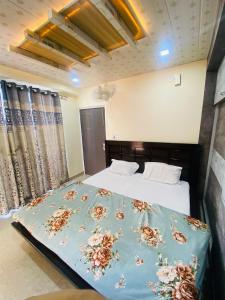 a bedroom with a bed with a blue comforter at Rivervalley View Homestay in Kandāghāt