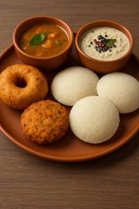 a plate of food with soup and donuts and dip at TrueLife Nexus Suites in Tirupati +16 photos