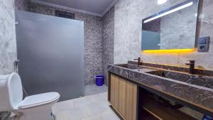 a bathroom with a sink and a toilet and a mirror at Central Premium Holiday Homes - Marché, Corniche & Océan à pied in Larache +19 photos