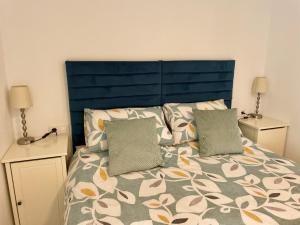 a bed with a blue head board and two pillows at The Town House - Mojacar in Mojácar
