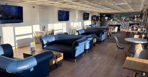 a restaurant with blue couches and tables and chairs at Hoburne Devon Bay - 2 Bed Caravan - Activity Passes Included in Goodrington