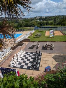 a chess board on a patio next to a pool at Hoburne Devon Bay - 2 Bed Caravan - Activity Passes Included in Goodrington