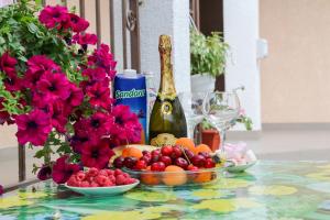 a table with a bowl of fruit and a bottle of champagne at Hotel Kings Zatoka in Zatoka