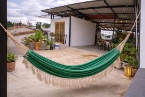 a green hammock hanging from a roof at Durán Business Suites near Airport in Bogotá