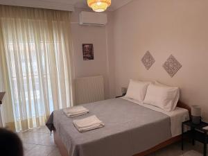 a bedroom with a bed with two towels on it at Summer Comfort Apartment in Nea Kallikrateia