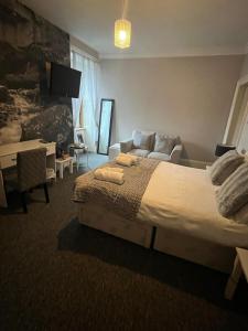 a bedroom with a large bed and a couch at Ugie House in Keith +4 photos
