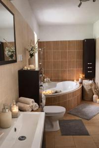 a bathroom with a tub and a toilet and a sink at Holiday House Jana in Muráň