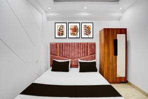 a bedroom with a bed with a red headboard at Hotel O Maxico in New Delhi