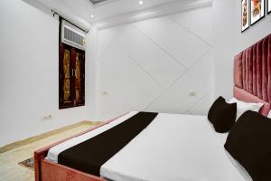 a bedroom with a bed and a window at Hotel O Maxico in New Delhi