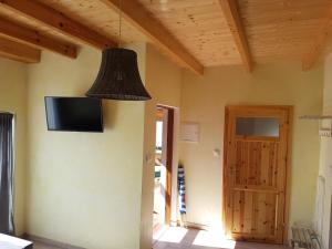 a room with a tv on the wall and a door at Domki Oaza Spokoju in Władysławowo