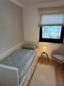 a bed in a room with a window and a chair at WohlfühlWerk L7 in Mechernich