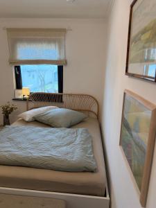 a small bedroom with a bed and a window at WohlfühlWerk L7 in Mechernich
