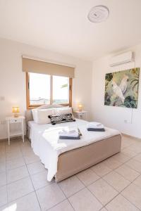 a bedroom with two beds and a painting on the wall at Casa Alba Modern Boho Villa with private Pool near to Sea, Paphos in Peyia +84 photos