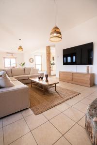 a living room with a couch and a table at Casa Alba Modern Boho Villa with private Pool near to Sea, Paphos in Peyia