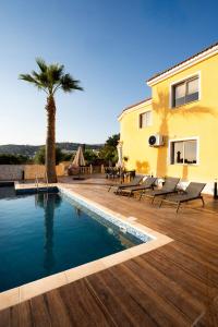 a villa with a swimming pool and a palm tree at Casa Alba Modern Boho Villa with private Pool near to Sea, Paphos in Peyia