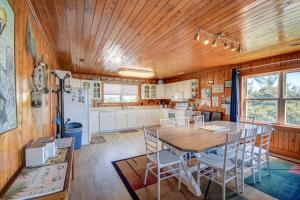 a kitchen with a wooden ceiling and a table and chairs at Wave To Cool in Surf City