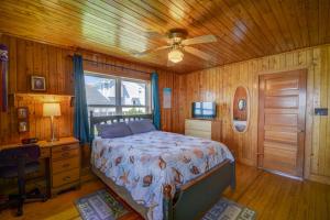 a bedroom with a bed and a desk and a ceiling fan at Wave To Cool in Surf City