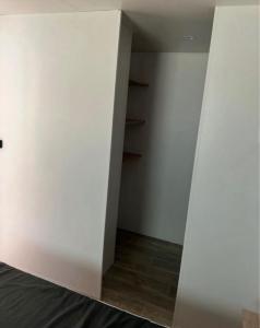 an empty room with white walls and wooden floors at La pomme de Pin in Étaples