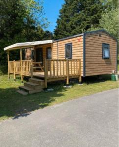 a log cabin with a porch and a deck at La pomme de Pin in Étaples