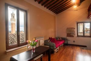 a living room with a couch and a table at Il NIDO-Attico Siena Centro con vista Duomo e Torre Del Mangia in Siena