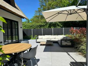 a patio with a couch and a table and an umbrella at Suite Heiloo in Heiloo +6 photos