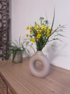 a white vase with yellow flowers in it on a table at Johlie in Oeyregave