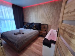 a bedroom with a large bed and a red light at Mostique Spa Apartment with Jacuzzi in Gdańsk