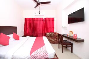a bedroom with a bed with a red curtain at Hotel O Dwarika Inn in Jabalpur +29 photos