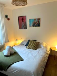 a bedroom with a large white bed with two pillows at Au perron avec garage et balcon à Ribeauville in Ribeauvillé