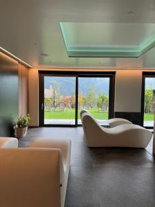 a living room with couches and a large window at Miramontino Mountain Suite & Spa in Rota d'Imagna