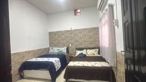 a bedroom with two beds and a window at Casa Borges leal in Santarém