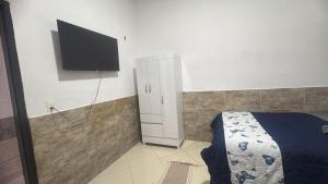 a bedroom with a bed and a flat screen tv at Casa Borges leal in Santarém
